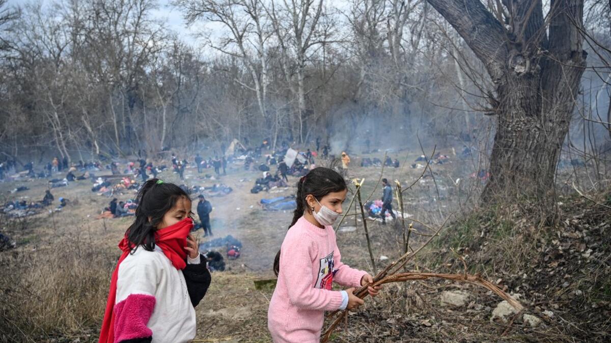 Children collect branches as migrants wait to pass the buffer zone at Turkey-Greece border at Pazarkule, in Edirne district, on February 29, 2020. Thousands of migrants stuck on the Turkey-Greece border clashed with Greek police on February 29, 2020, according to an AFP photographer at the scene.OZAN KOSE / AFP