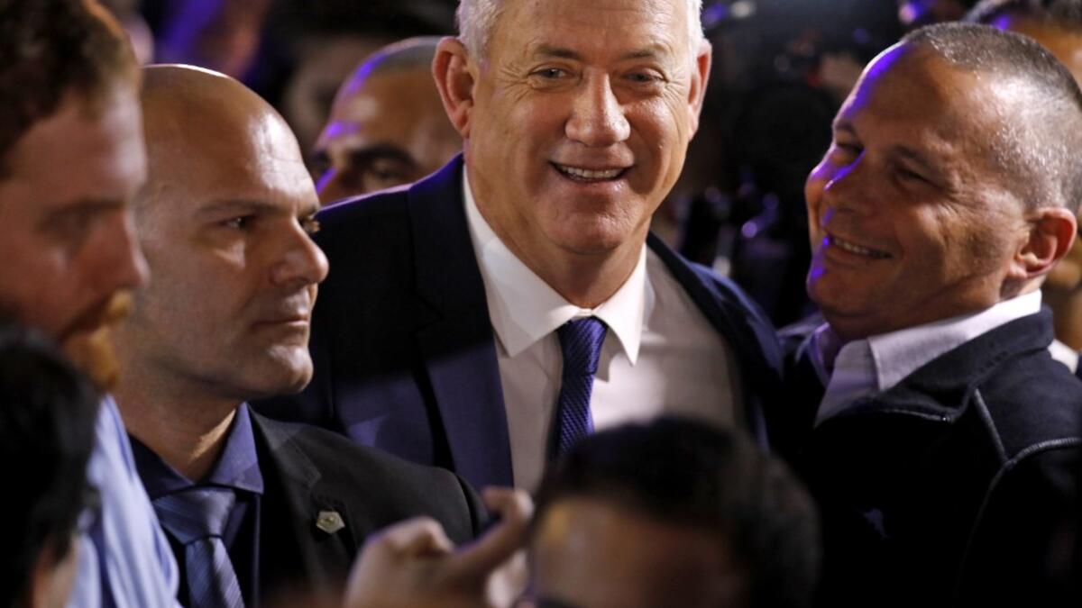 Blue and White (Kahol Lavan) electoral alliance leader Benny Gantz (C) greets supporters at their campaign headquarters in the coastal city of Tel Aviv early on March 3, 2020, after polls officially closed. Menahem KAHANA / AFP