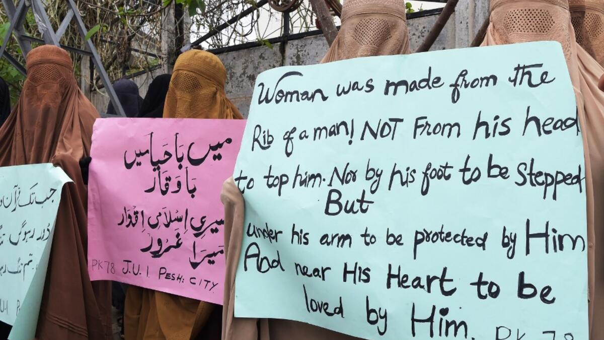 Burqa-clad female activists of Islamic political party Jamiat Ulema-e-Islam (JUI-F), carry placards during a rally to mark the International Women's Day in Peshawar on March 8, 2020. Thousands of people are expected to rally in cities across Pakistan on March 8 to mark International Women's Day in an ultra-conservative society where women are still put to death under ancient "honour" codes. Abdul MAJEED / AFP