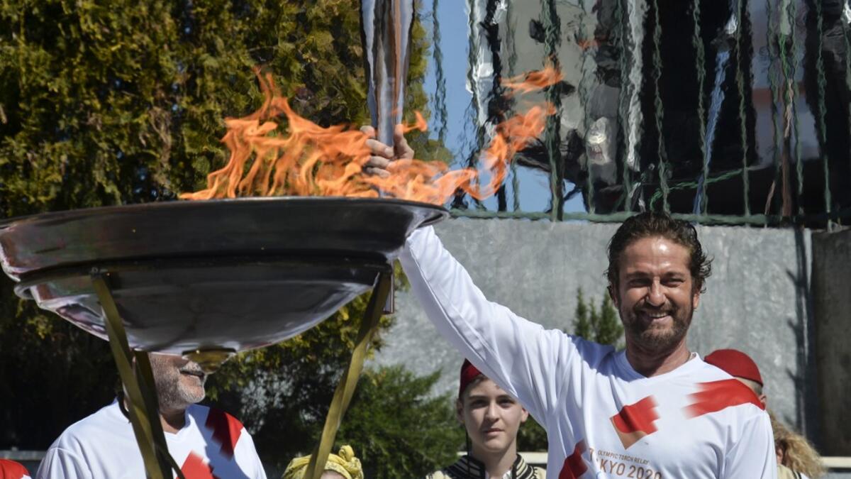 US actor Gerard Butler poses with the Olympic flame during the Olympic flame relay in Sparta on March 13, 2020 ahead of the Tokyo 2020 Olympic Games. Valerie Gache / AFP
