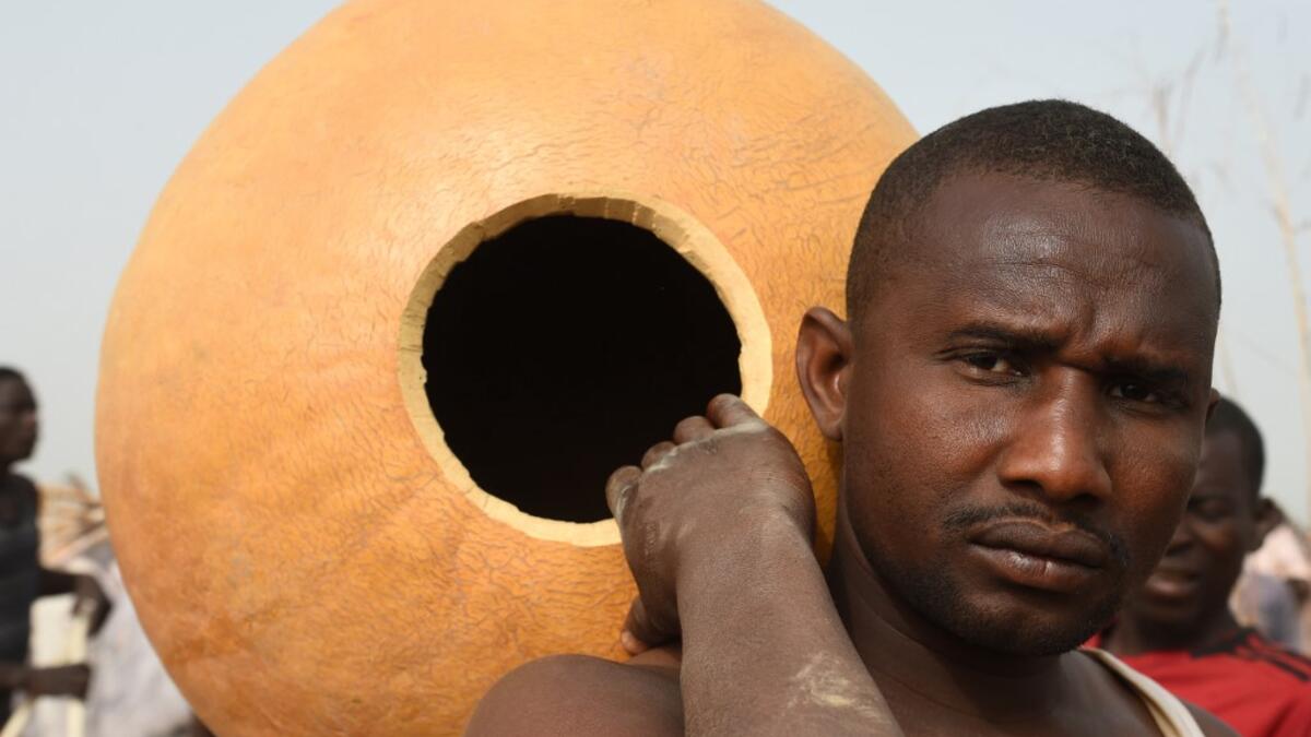 A fisherman carries a calabash and prepares to attend the Argungu fishing and cultural festival at Argungu Town, Kebbi State, in northwest Nigeria, on March 14, 2020. Argungu fishing and cultural festival is one of the oldest and most widely attended festivals in the country dating back many generations, featuring series of water competitions and traditional games. The festival returned after 10 years suspension due to insecurity in northwest Nigeria. PIUS UTOMI EKPEI / AFP