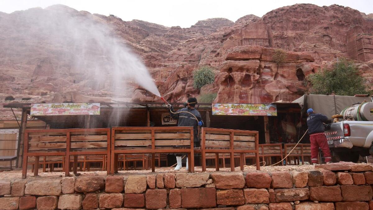 A labourer sprays disinfectant in Jordan's archaeological city of Petra south of the capital Amman on March 17, 2020, to prevent the spread of COVID-19. Khalil MAZRAAWI / afp