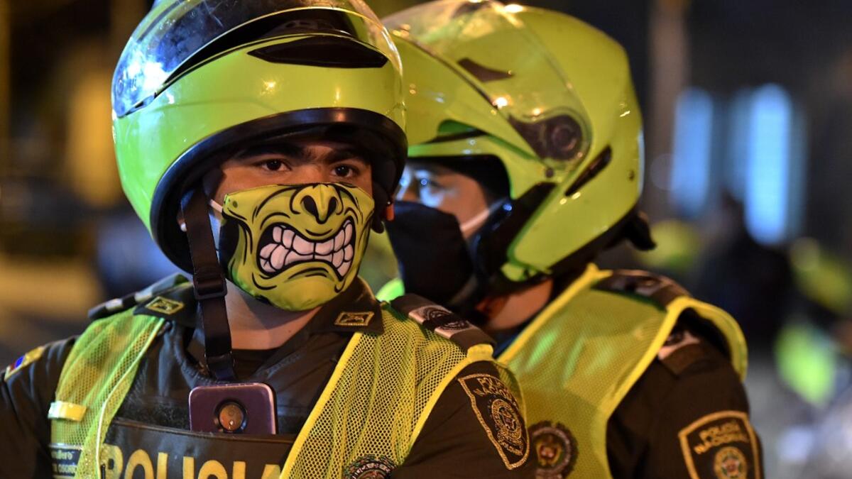 Police officers use face masks as a preventive measure against the spread of the new coronavirus, COVID-19, in Cali, Colombia on March 20, 2020. Colombian authorities announced a mandatory isolation simulation for the extended weekend, from March 21 to 23, as a preventive measure against the spread of the new coronavirus, COVID-19. Luis ROBAYO / AFP