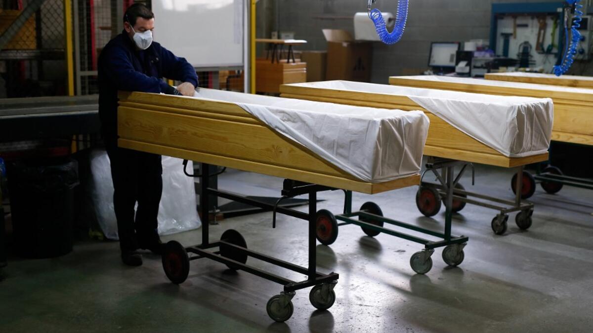 An employee covers coffins at the Eurocoffin coffins factory in Barcelona on April 3, 2020. More than 900 people died in Spain over the past 24 hours for the second day running, government figures showed, although the rate of new infections and deaths continued to slow. Spain has the world's second-highest death toll after Italy with the virus so far claiming 10,935 lives from 117,710 confirmed cases.  PAU BARRENA / AFP