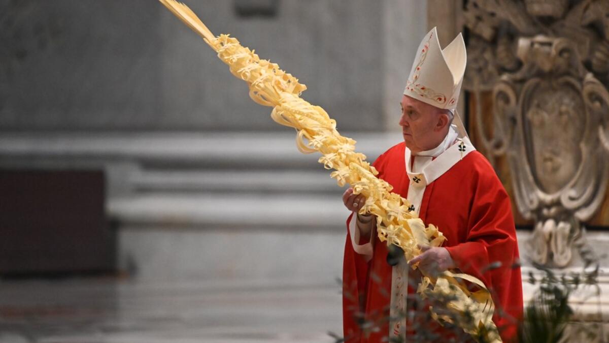 Pope Francis holds a palm branch as he celebrates Palm Sunday mass behind closed doors at St. Peter's Basilica mass on April 5, 2020 in The Vatican, during the lockdown aimed at curbing the spread of the COVID-19 infection, caused by the novel coronavirus. Alberto PIZZOLI / POOL / AFP