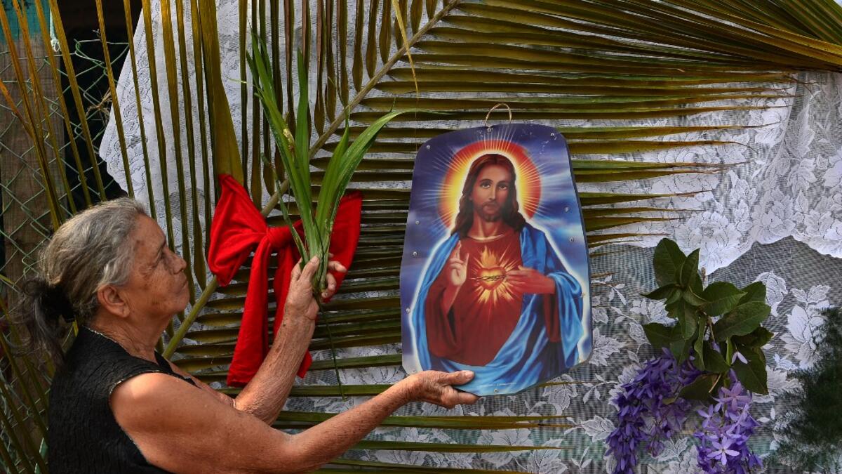 A woman prepares an altar at her house in Tegucigalpa on Palm Sunday on April 5, 2020, as all activities, including religious festivities during Holy Week, have been suspended under the curfew ordered by the Honduran government to help curb the spread of the novel coronavirus, COVID-19. More than 1.2 million cases, including 65,272 deaths, have been reported in 190 countries and territories around the world since the virus first emerged in China in December, according to an AFP tally compiled around 1100 GM