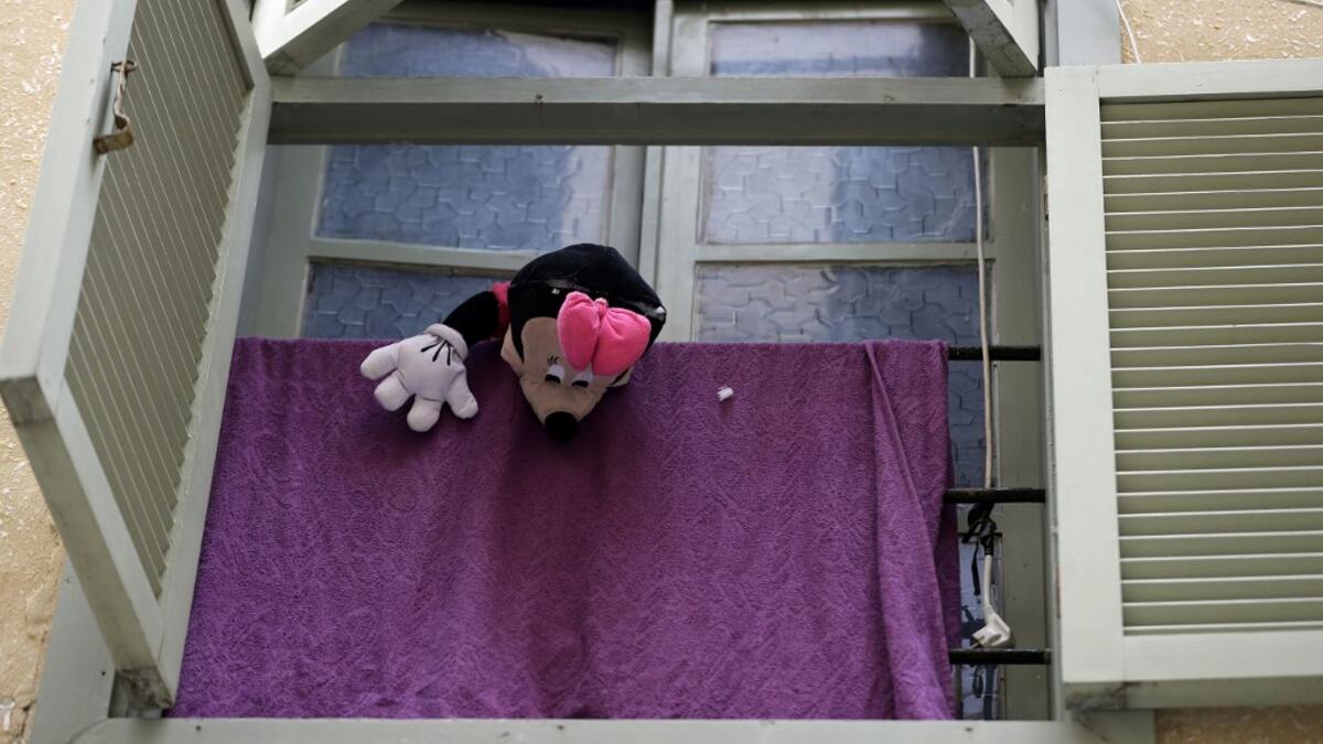 A Minnie Mouse stuffed toy dangles from a window as families are confined at home amid the COVID-19 pandemic crisis, in the historic part of the southern coastal city of Sidon (Saida), on April 6, 2020. Lebanon's President called on international donors to provide financial assistance to the crisis-hit country as it grapples with a severe economic downturn compounded by the novel coronavirus pandemic. JOSEPH EID / AFP