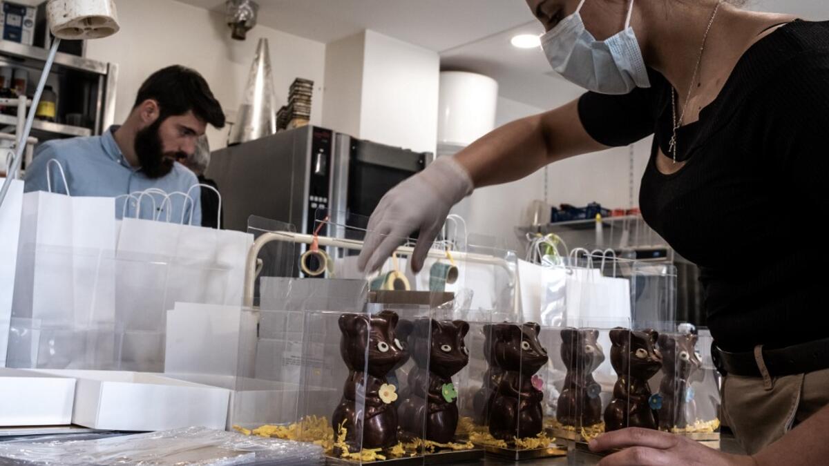 Employees of pastry and chocolate maker Didier Girard prepare Easter chocolates before delivering them at clients' homes in Vourles, near Lyon at on April 7, 2020, on the twenty-second day of a strict lockdown in France to stop the spread of COVID-19, caused by the novel coronavirus. JEAN-PHILIPPE KSIAZEK / AFP