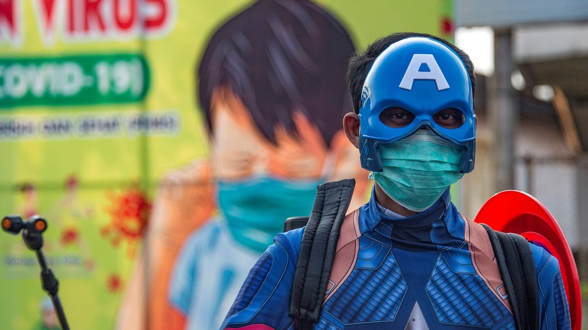 An Indonesian police officer wearing a superhero costume on the street disinfects motorists' vehicles in Pasuruan, East Java on April 9, 2020, amid concert to the COVID-19 coronavirus. JUNI KRISWANTO / AFP