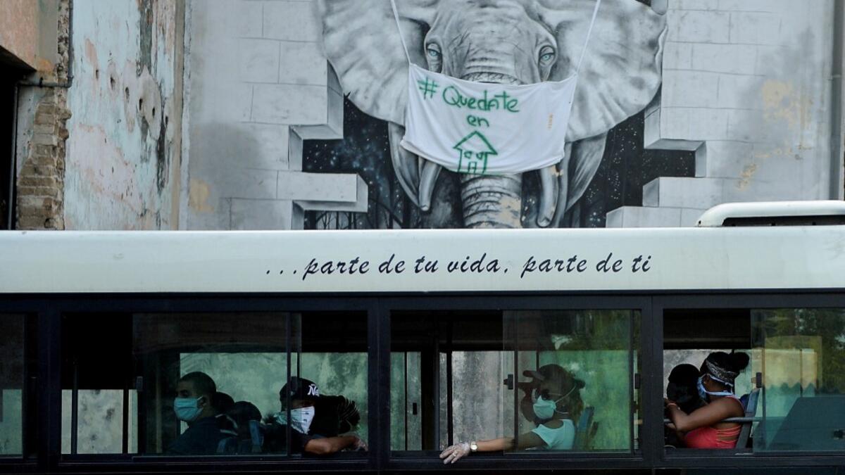 Commuters wear face masks aboard a bus in Havana, on April 11, 2020. Cuba hit out at the United States on Friday over its nearly 60-year-old embargo against the island nation, which Havana described as "even more cruel" given the suffering caused by the new coronavirus pandemic. The communist-run single-party island is finding it tough to source medical supplies and has already recorded 620 coronavirus cases and 16 deaths. YAMIL LAGE / AFP