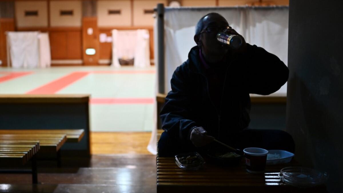 Katsuya Asao, 54, eats before resting at a shelter provided by Kanagawa prefecture for the people, who can’t afford to rent an apartment and used to stay at designated internet cafes, which are closed due to the COVID-19 coronavirus outbreak state of emergency, at a Judo sport hall in Yokohama, Kanagawa prefecture on April 13, 2020. CHARLY TRIBALLEAU / AFP