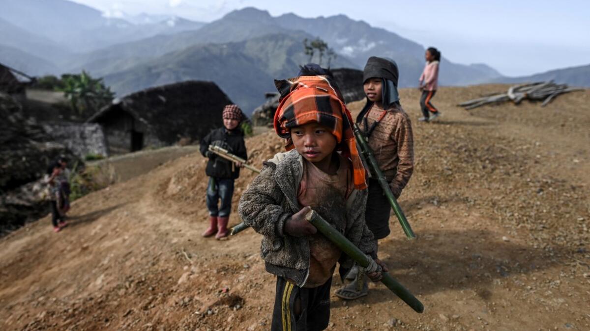 This photo taken on February 9, 2020 shows children playing in Karmawlawyi village in Myanmar's Sagaing region, near the border with India. The king of the Konyak tribe sleeps in Myanmar, but eats in India -- his house, village and people divided by a mountain border which serves as a vulnerable lifeline now severed by a coronavirus lockdown.  Ye Aung THU / AFP