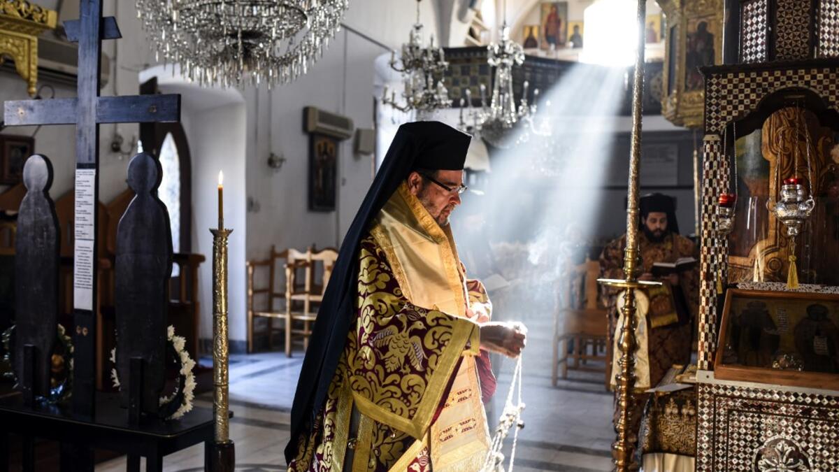 Bishop Nikodimos of Nitria, Exarch of the Patriarchate of Alexandria in Cyprus, swings an incense censer by the epitaphios (a religious icon made of an embroidered cloth used as a re-enactment of the body of Christ), during the Holy Saturday Matins at the Greek Orthodox Church of Saint Savvas in the old walled city of the Cypriot capital Nicosia on April 17, 2020, as prayers are held without a congregation due to the COVID-19 coronavirus pandemic. Amir MAKAR / AFP