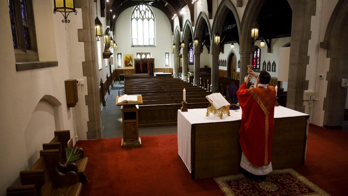 Father Peter Turrone leads a Palm Sunday mass to an empty church at the St. Thomas Aquinas Catholic Church on April 5, 2020 in Toronto, Canada. Cole Burston / GETTY IMAGES NORTH AMERICA / Getty Images via AFP
