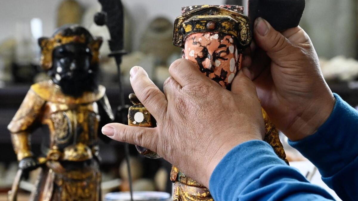 In this picture taken on March 17, 2020, sculptor Lin Hsin-lai restoring a Taoist god statue at his workplace in Taoyuan, northern Taiwan on March 17, 2020.Sam Yeh / AFP