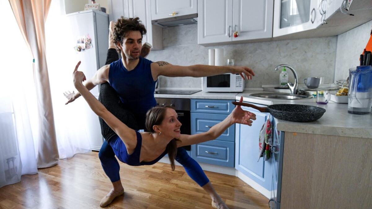 Bolshoi theatre leading soloist Igor Tsvirko and first soloist Margarita Shrainer attend a lesson in the kitchen of their apartment in Moscow on April 29, 2020 during a strict lockdown in Russia to stop the spread of the COVID-19 infection caused by the novel coronavirus. In the middle of their bedroom. Kirill KUDRYAVTSEV / AFP