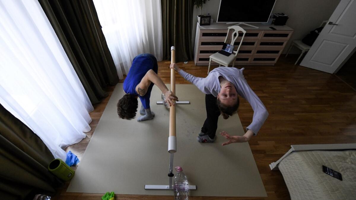 Bolshoi theatre leading soloist Igor Tsvirko and first soloist Margarita Shrainer attend a lesson in their apartment in Moscow on April 29, 2020 during a strict lockdown in Russia to stop the spread of the COVID-19 infection caused by the novel coronavirus. Kirill KUDRYAVTSEV / AFP