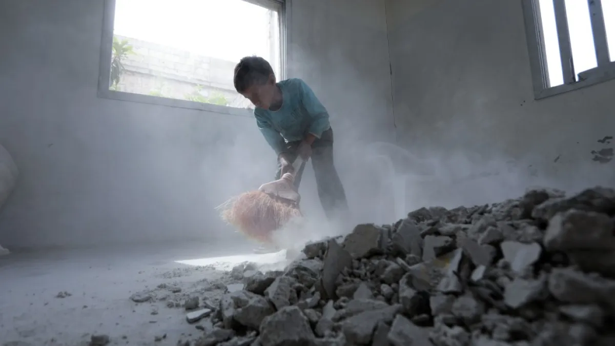 A Syrian youth whose family decided to return home for fear of the COVID-19 pandemic in packed camps for the internally displaced, cleans the rubble from a room in his house in al-Nayrab, a village ravaged by pro-government forces bombardment near the M4 strategic highway, in Syria's northwestern Idlib province, on May 3, 2020. Bakr ALKASEM / AFP