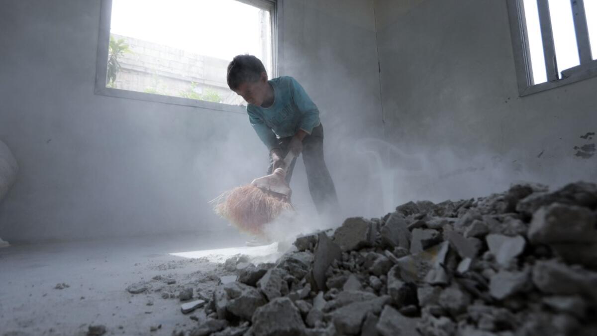 A Syrian youth whose family decided to return home for fear of the COVID-19 pandemic in packed camps for the internally displaced, cleans the rubble from a room in his house in al-Nayrab, a village ravaged by pro-government forces bombardment near the M4 strategic highway, in Syria's northwestern Idlib province, on May 3, 2020. Bakr ALKASEM / AFP