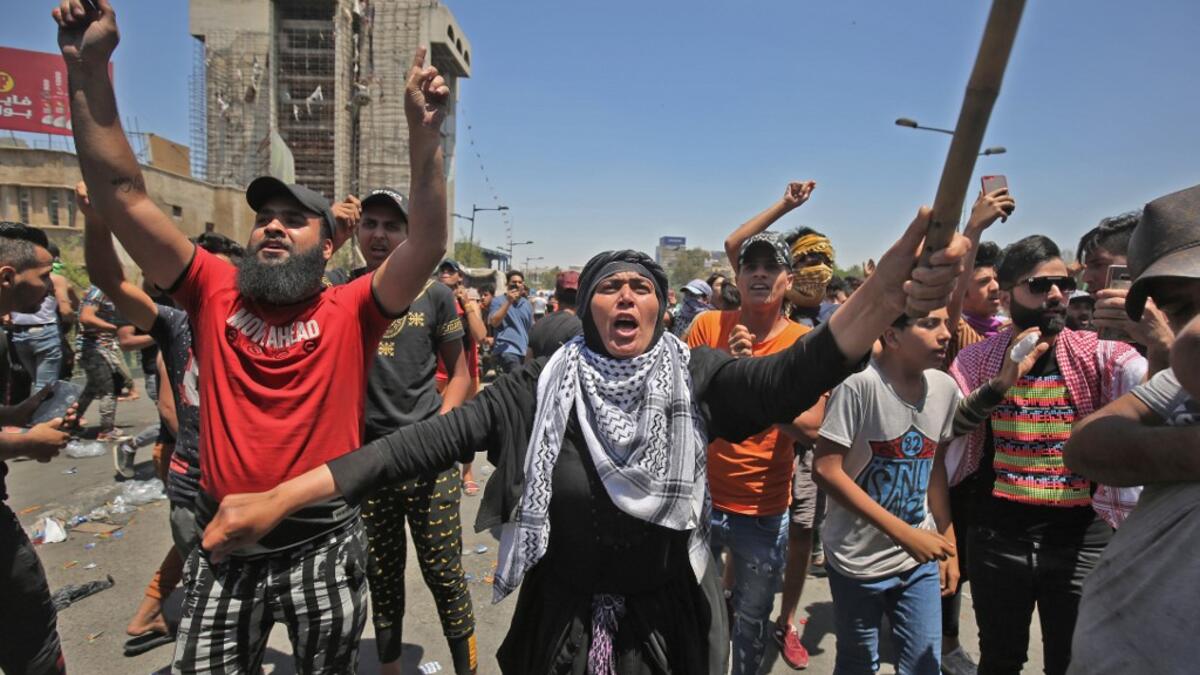 A woman shouts slogans as she takes part with Iraqi protesters in an an anti-government demonstration on Al-Jumhuriyah bridge in the capital Baghdad, on May 10,2020. Modest anti-government rallies resumed in some Iraqi cities today, clashing with security forces and ending months of relative calm just days after Prime Minister Mustafa Kadhemi's government came to power. AHMAD AL-RUBAYE / AFP