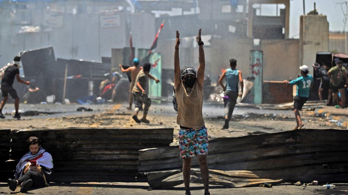 Iraqi protesters hurl rocks toward security forces as they clash with them during an anti-government demonstration on Al-Jumhuriyah bridge in the capital Baghdad, on May 10,2020. Modest anti-government rallies resumed in some Iraqi cities today, clashing with security forces and ending months of relative calm just days after Prime Minister Mustafa Kadhemi's government came to power. AHMAD AL-RUBAYE / AFP