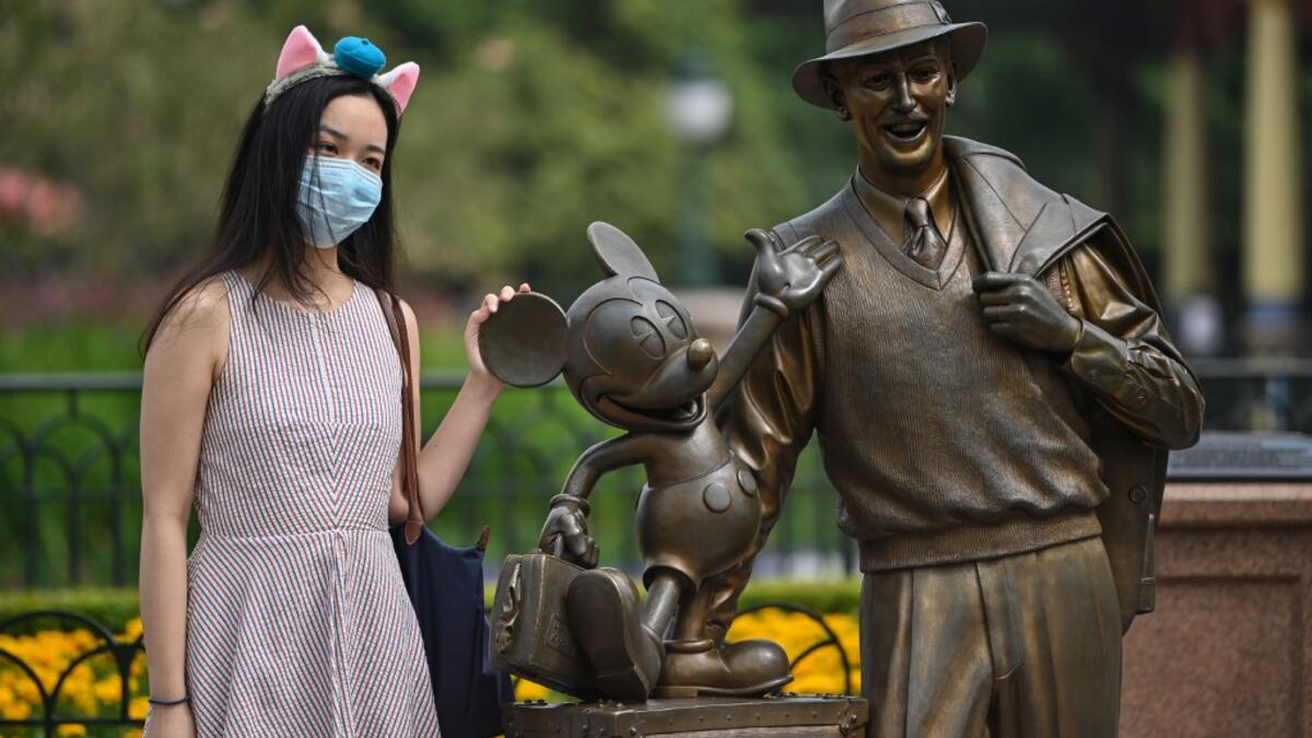 A woman wearing a face masks visits the Disneyland amusement park in Shanghai on May 11, 2020. Disneyland Shanghai reopened on May 11 to the public after being closed since January due to the COVID-19 coronavirus outbreak. Hector RETAMAL / AFP