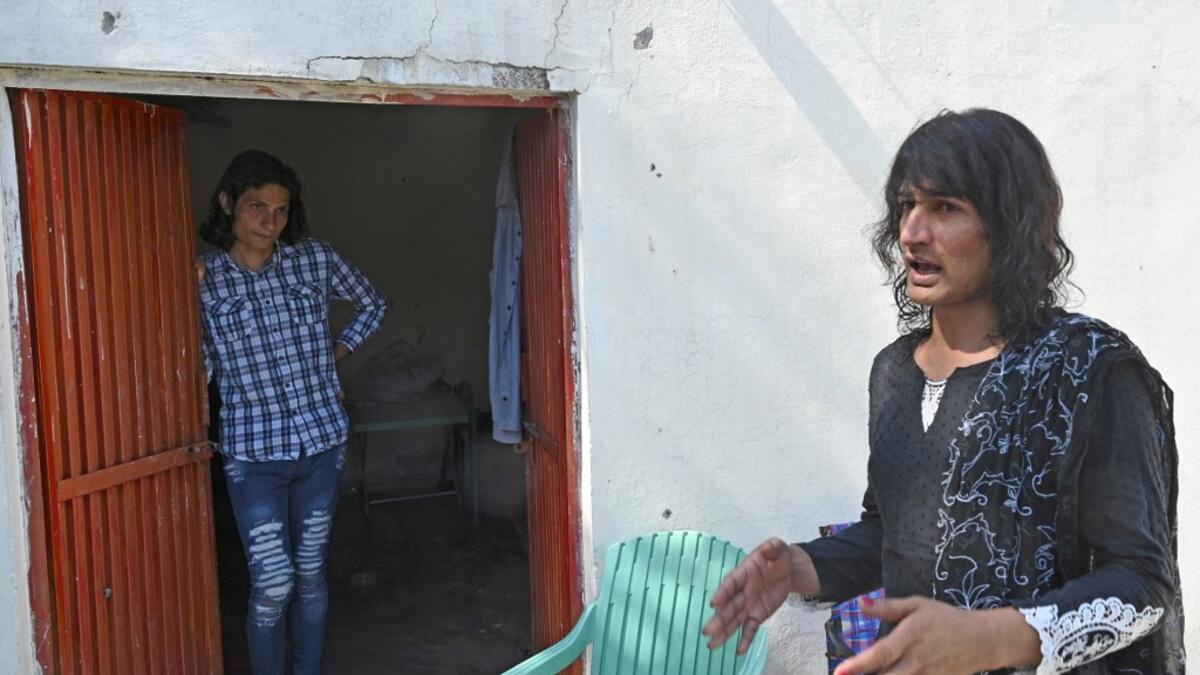 In this picture taken on May 8, 2020, transgenders Adnan Ali (L) and Julie Khan (R) stand outside a shelter house in the Bari Imam neighbourhood of Islamabad. Transgender people in the country are known as "khawajasiras" or "hijras" -- an umbrella term denoting a third sex that includes transgender women and cross-dressers. Pakistan became one of the first countries in the world to legally recognise a third sex in 2009 and began issuing transgender passports from 2017. Aamir QURESHI / AFP