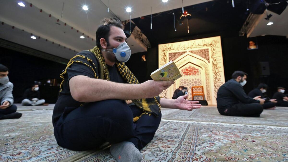 An Iranian man wearing a face mask against the Covid-19 coronavirus attends Laylat al-Qadr prayers, one of the holiest nights during the Muslim fasting month of Ramadan, outside a mosque in the Tehran, on May 13, 2020. ATTA KENARE / AFP