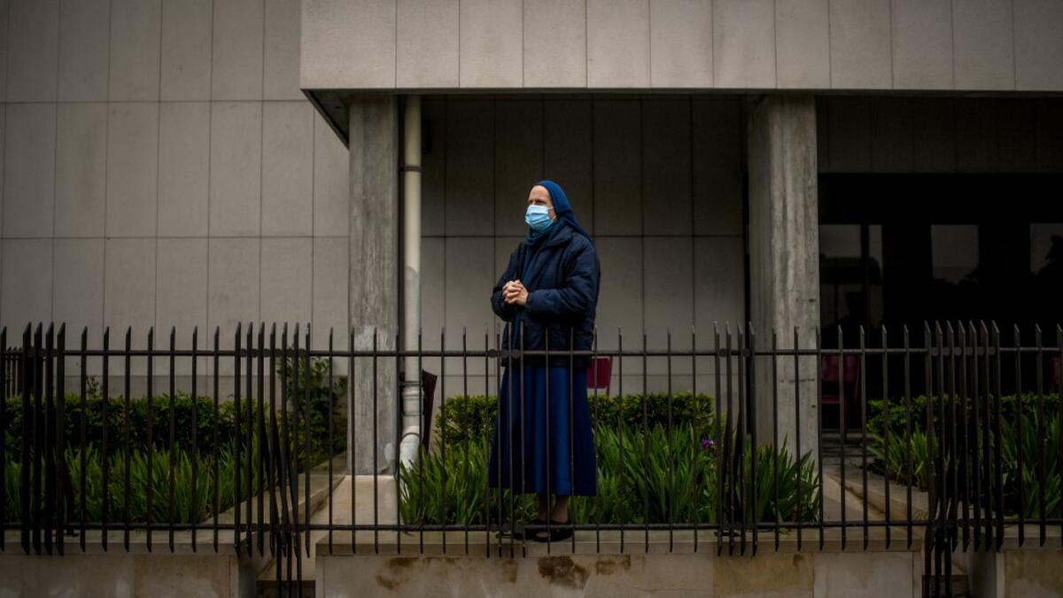A nun wearing a face mask attends a ceremony marking the 103rd anniversary of the apparitions of Our Lady of Fatima at the Fatima shrine in central Portugal, on May 13, 2020. Without the crowd of pilgrims it welcomes every year, the shrine of Fatima celebrated the anniversary during a religious ceremony reduced to the bare minimum. PATRICIA DE MELO MOREIRA / AFP