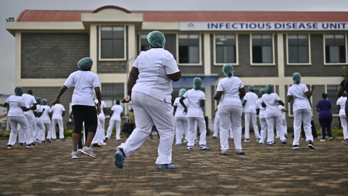 Nurses assigned to the Infectious Diseases Unit (IDU) at the Kenyatta University Hospital dance during a Zumba class held at the hospital compound in Nairobi, on May 17, 2020. Coinciding with the morning shift rotation the class, aimed to offer some respite to nurses charged with the management of patients infected with COVID-19 coronavirus, was organised by the Nursing Council of Kenya (NCK) and the Kenyatta Univesity Teaching, Refferal and Research Hospital in the Kenyan capital. TONY KARUMBA / AFP