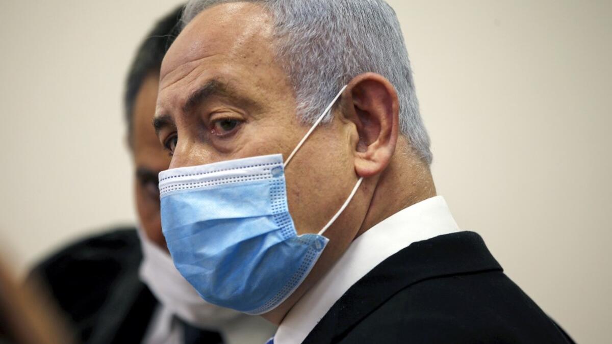 Israeli Prime Minister Benjamin Netanyahu, wearing a protective face maks, is pictured inside a courtroom at the district court of Jerusalem on May 24, 2020, during the first day of his corruption trial. Fresh from forming a new government after more than 500 days of electoral deadlock, Netanyahu is expected to begin a new battle in the Jerusalem District Court -- to stay out of prison. The 70-year-old was scheduled to appear at a court hearing to formally confirm his identity to judges, after being indicte