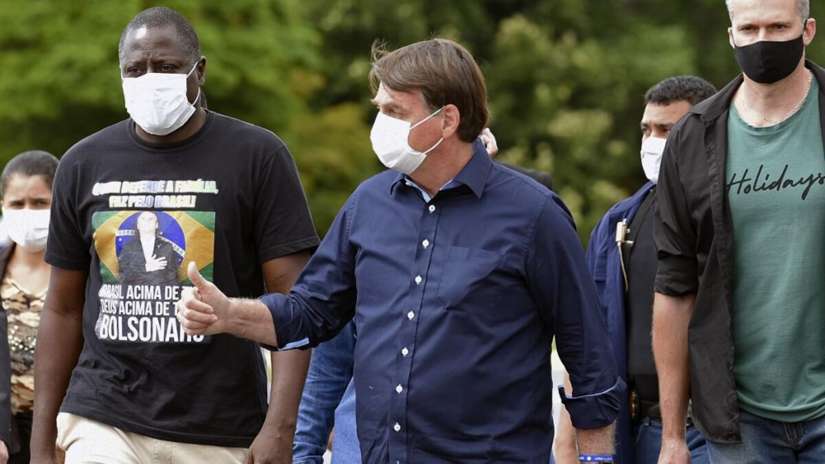 Brazil's President Jair Bolsonaro gives his thumb up upon arrival at Planalto Palace in Brasilia, on May 24, 2020, amid the COVID-19 coronavirus pandemic. Despite positive signs elsewhere, the disease continued its surge in large parts of South America, with the death toll in Brazil passing 22,000 and infections topping 347,000, the world's second-highest caseload. EVARISTO SA / AFP