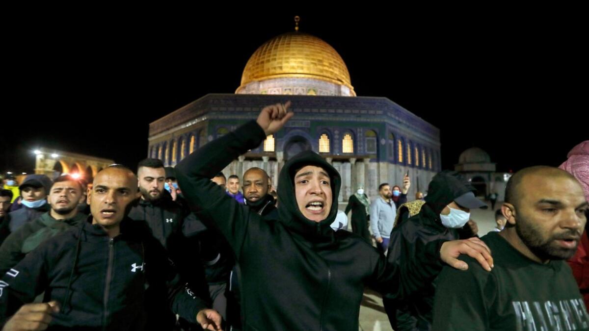 Palestinian men react as they walk in front of the Dome of Rock at the Al-Aqsa Mosque compound, before the start of the dawn prayer (salat al-fajr) inside the compound in Jerusalem's Old City, on May 31, 2020, after a two-month closure due to the COVID-19 pandemic. AHMAD GHARABLI / AFP