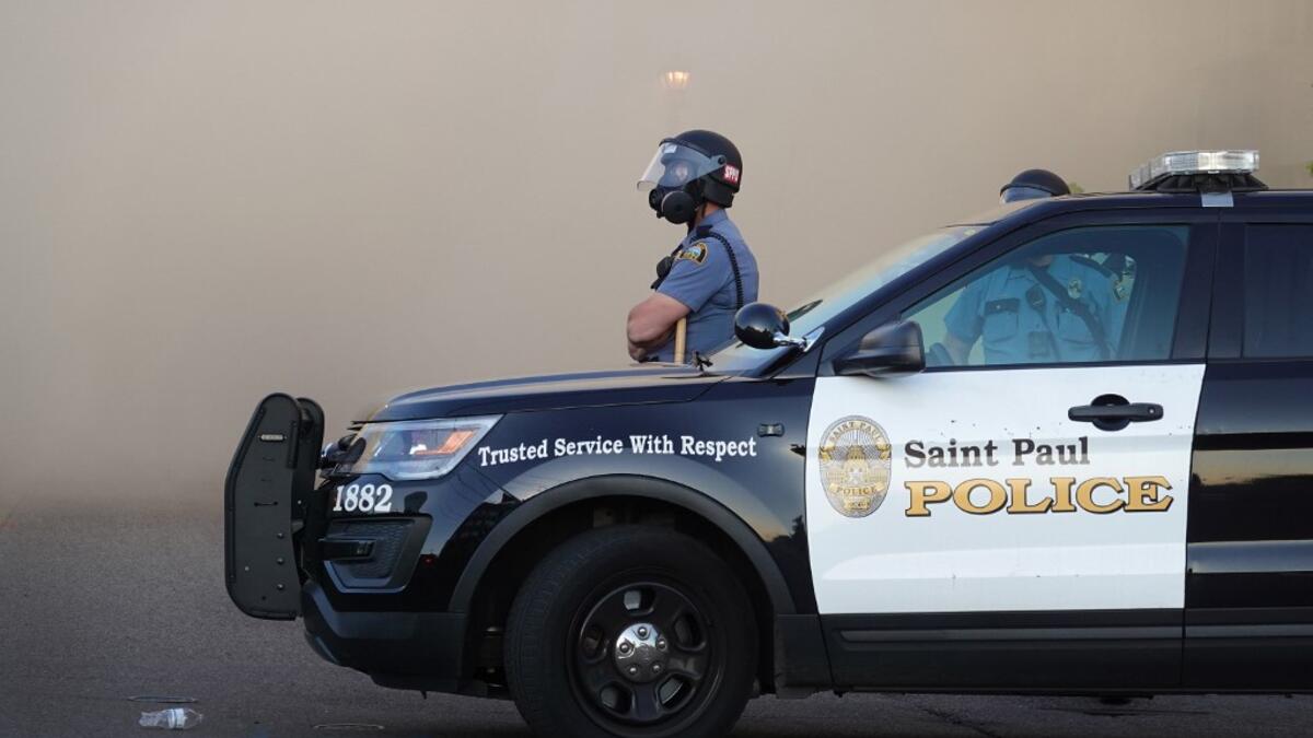 A police officer watches a retail store burn during a protest on May 28, 2020 in St. Paul, Minnesota. Today marks the third day of ongoing protests after the police killing of George Floyd. Four Minneapolis police officers have been fired after a video taken by a bystander was posted on social media showing Floyd's neck being pinned to the ground by an officer as he repeatedly said, "I cant breathe."SCOTT OLSON / GETTY IMAGES NORTH AMERICA / Getty Images via AFP