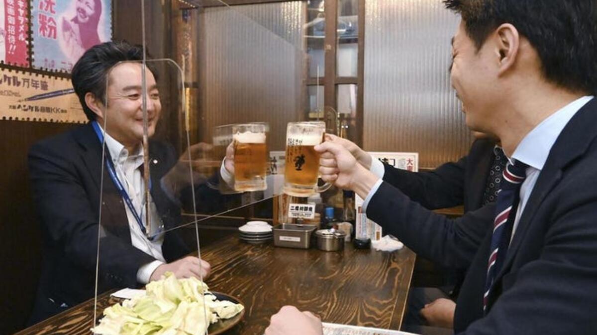 في أحد مطاعم اليابان لا يزال بإمكان الأصدقاء الجلوس معًا، ولكن تم وضع حواجز زجاجية على الطاولات.