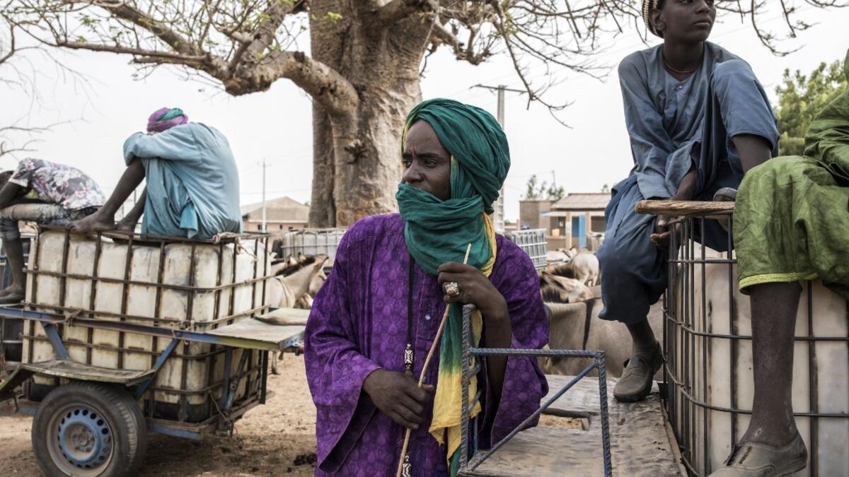 Fulani herders wait to fill their water tanks at a water point in Dolly on May 30, 2020. Dolly is a pastoral reserve where Fulani pastoralists can come as a refuge before heading back North as the first rains fall. COVID-19 coronavirus restrictions have closed down markets and regional movement, as a result Fulani herders are struggling to move to areas such as Dolly which have more grazing land and access to water. JOHN WESSELS / AFP