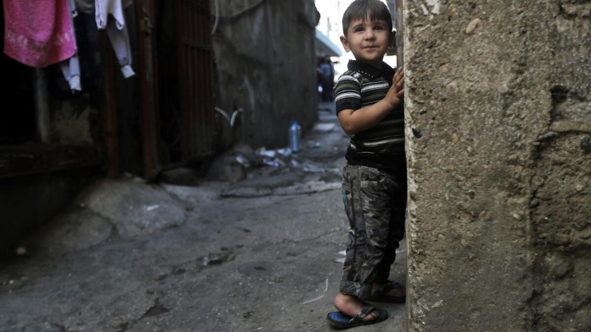 A child looks on while standing along the wall of a building along an alley in the Bab al-Tabbaneh neighbourhood of Lebanon's northern city of Tripoli on June 3, 2020. Thousands of residents of Lebanon's northern Tripoli struggle to put food on the table, as the country's worst economic crisis in decades has picked up in speed in recent weeks, with food prices rising by more than 70 percent since the autumn. Inflation has been a blow in the country where more than 45 percent of the country's population now