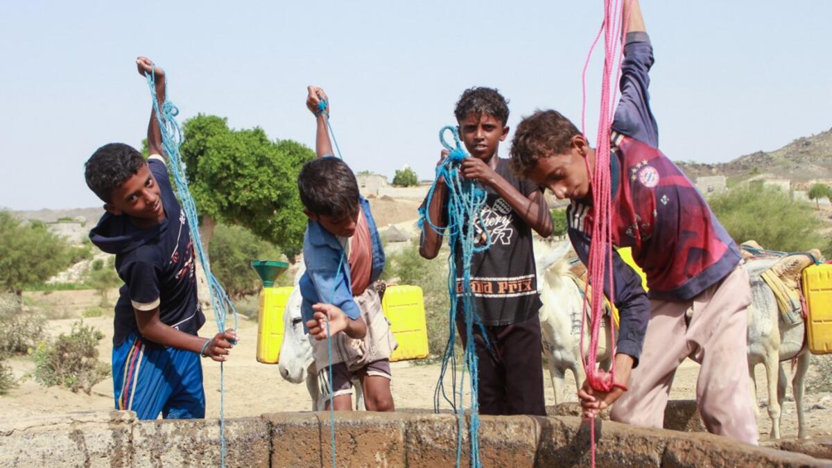 Yemeni youths fill jerrycans carried by donkeys with water from a cistern at a make-shift camp for the internally displaced, in the northern Hajjah province, on June 7, 2020, amid a severe shortage of water. ESSA AHMED / AFP