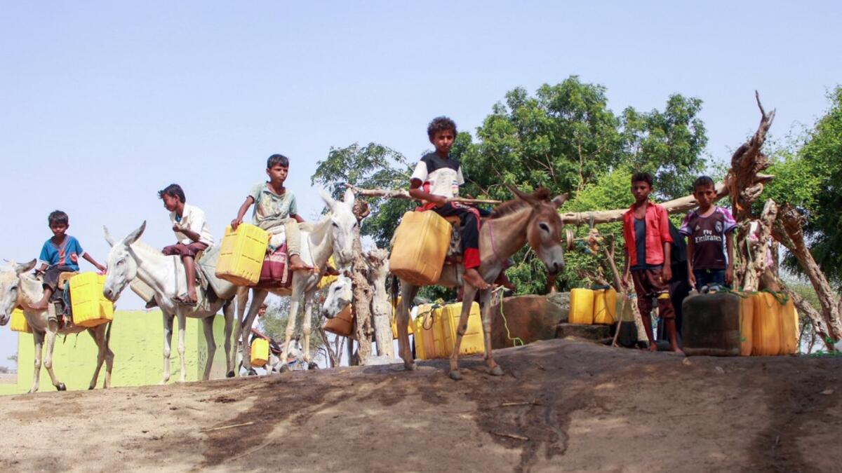 Yemeni youths, some riding donkeys, wait to fill their jerrycans with water from a cistern at a make-shift camp for the internally displaced, in the northern Hajjah province, on June 7, 2020, amid a severe shortage of water. ESSA AHMED / AFP