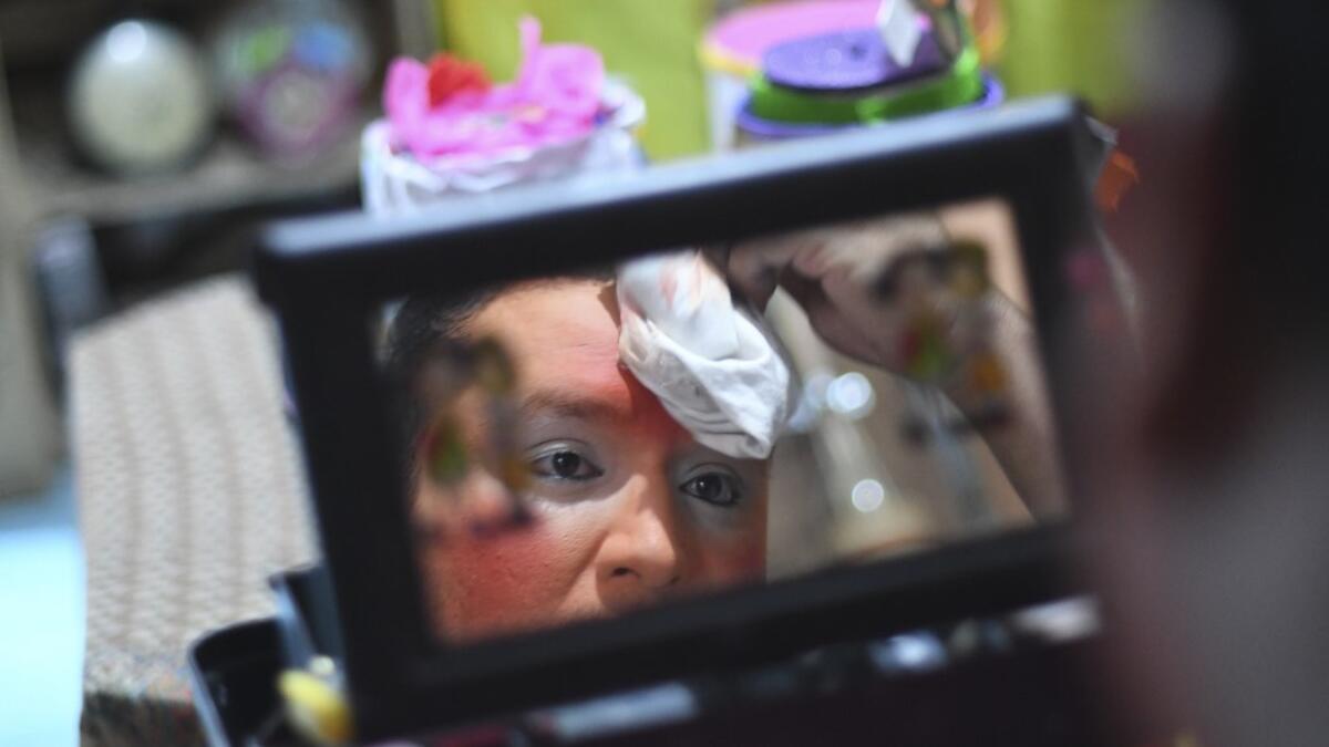 Chimbombita clown puts on make up before taking to the streets to beg for money to survive the crisis caused by the new coronavirus in Villa Nueva, 20 km south Guatemala City, on June 10, 2020, as clowns have been unable to work due to restrictions to prevent the spread of the COVID-19. Johan ORDONEZ / AFP