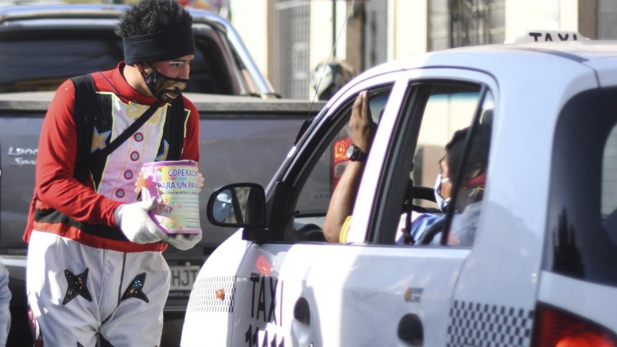 A clown begs for money to survive the crisis caused by the new coronavirus in Guatemala City, on June 9, 2020, as clowns have been unable to work due to restrictions to prevent the spread of the COVID-19.    Johan ORDONEZ / AFP