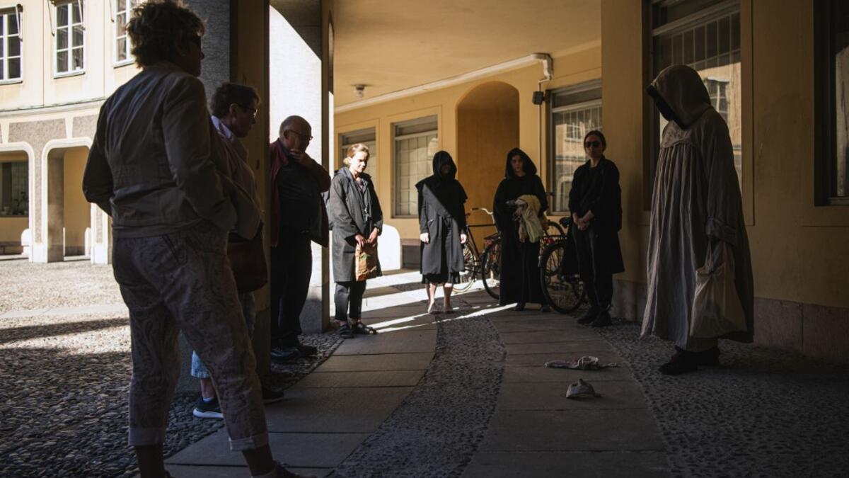 Tour guide Mike Anderson takes visitors on May 30 ,2020 on a 'plague walk', taking them around sites in Stockholm's old town related to pandemics of the plague in the 14th and 18th century, and an outbreak of cholera that hit the city in the mid-19th century. Jonathan NACKSTRAND / AFP