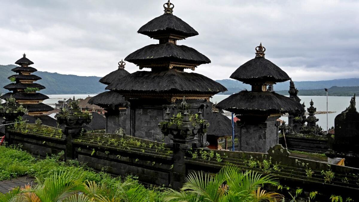 This picture taken on February 20, 2020 show a Balinese temple on the shores of Lake Batur near the village of Trunyan, home to the Trunyanese - who fuse animist beliefs and traditional village customs with their own interpretation of Hinduism - in Bangli Regency on Indonesia's Bali island. SONNY TUMBELAKA / AFP