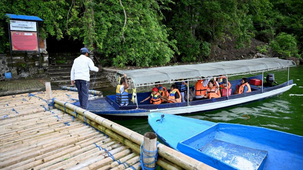 This picture taken on February 20, 2020 shows locals visiting a cemetery where Bali's Trunyanese people hold open-air burials - before restrictions were implemented due to the COVID-19 coronavirus - near the village of Trunyan in Bangli Regency, near Lake Batur on Bali island. SONNY TUMBELAKA / AFP