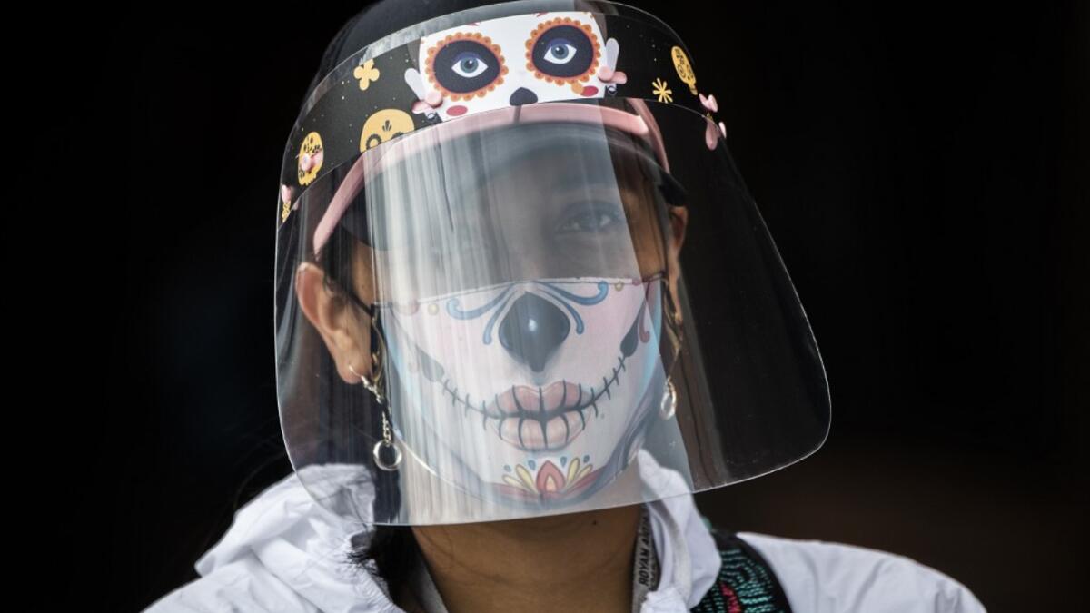 A municipal worker wears a face mask and shield at the Bosa neighborhood, one of the areas with more COVID-19 cases in Bogota, on June 17, 2020. Bogota is on alert for the high occupation of intensive care units amid the new coronavirus pandemic. Juan BARRETO / AFP