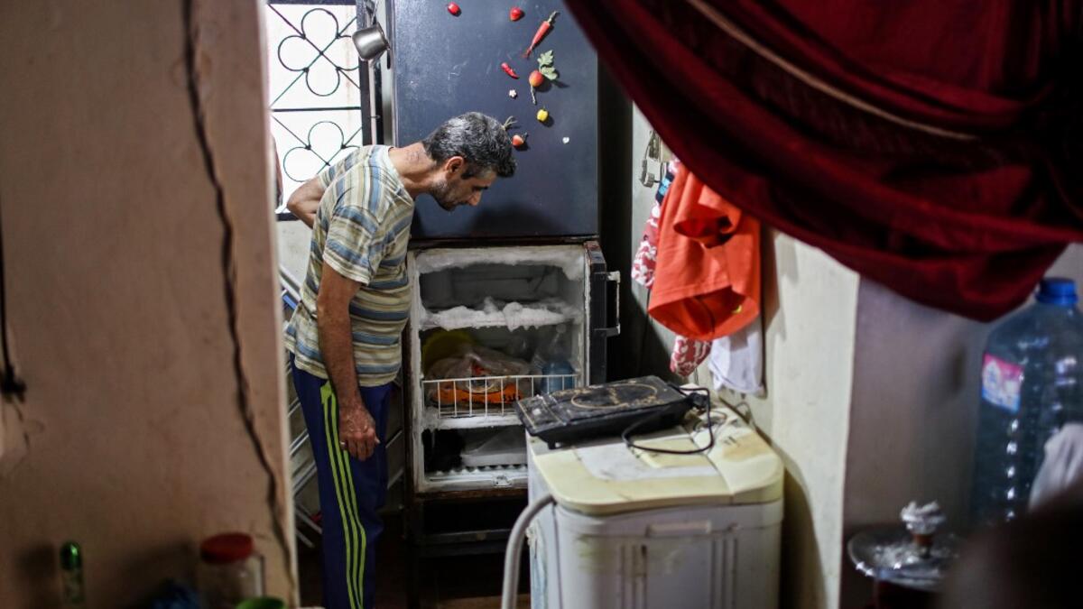 A Lebanese man looks at his empty refrigerator at his apartment in the capital Beirut on June 17, 2020. Lebanon's economic crisis has led to a collapse of the local currency and purchasing power, plunging whole segments of the population into poverty as exemplified by near-empty fridges in many households. ANWAR AMRO / AFP