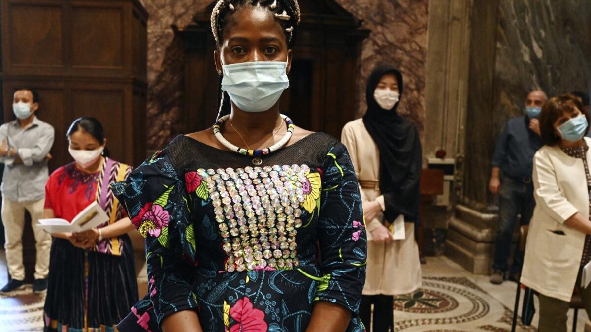 Faithful, wearing protective face masks over their traditional dress and respecting security distances, attend a vigil prayer for the deceased would be migrants as part of the International Migrants Day, in Rome's Basilica of Our Lady in Trastevere neighbourhood on June 18, 2020. The Community of Sant'Egidio organised a prayer for all 2039 people died in the Mediterranean during the 2019, speaking if even their name is today unknown to men, they are in the heart of God. Vincenzo PINTO / AFP