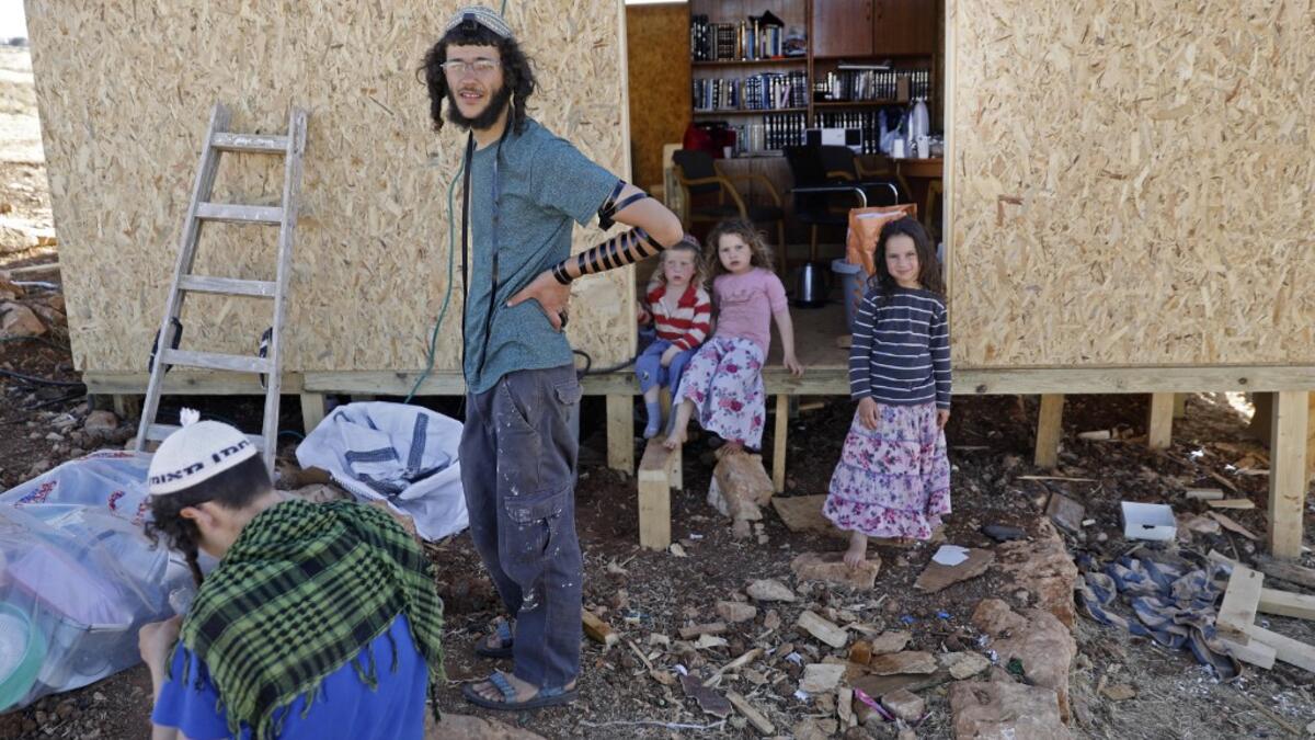 An Israeli settler wearing the Tefillin or phylacteries is picture at his home in the Maoz Ester outpost located next to the Israeli settlement of Kokhav HaShahar in the occupied West Bank on June 18, 2020. The government of Israeli Prime Minister Benjamin Netanyahu has said it could begin the process to annex Jewish settlements in the West Bank as well as the strategic Jordan Valley from July 1. The plan -- endorsed by Washington -- would see the creation of a Palestinian state, but on reduced territory, a