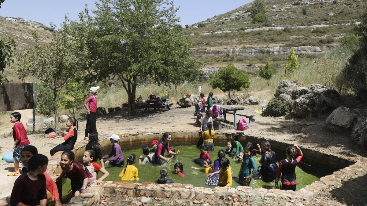 Israeli children from the nearby settlement of Shilo are pictured at a water spring on June 8, 2020 near the Palestinian village of Turmus‘ayya in the occupied West Bank. The government of Israeli Prime Minister Benjamin Netanyahu has said it could begin the process to annex Jewish settlements in the West Bank as well as the strategic Jordan Valley from July 1. The plan -- endorsed by Washington -- would see the creation of a Palestinian state, but on reduced territory, and without Palestinians' core demand