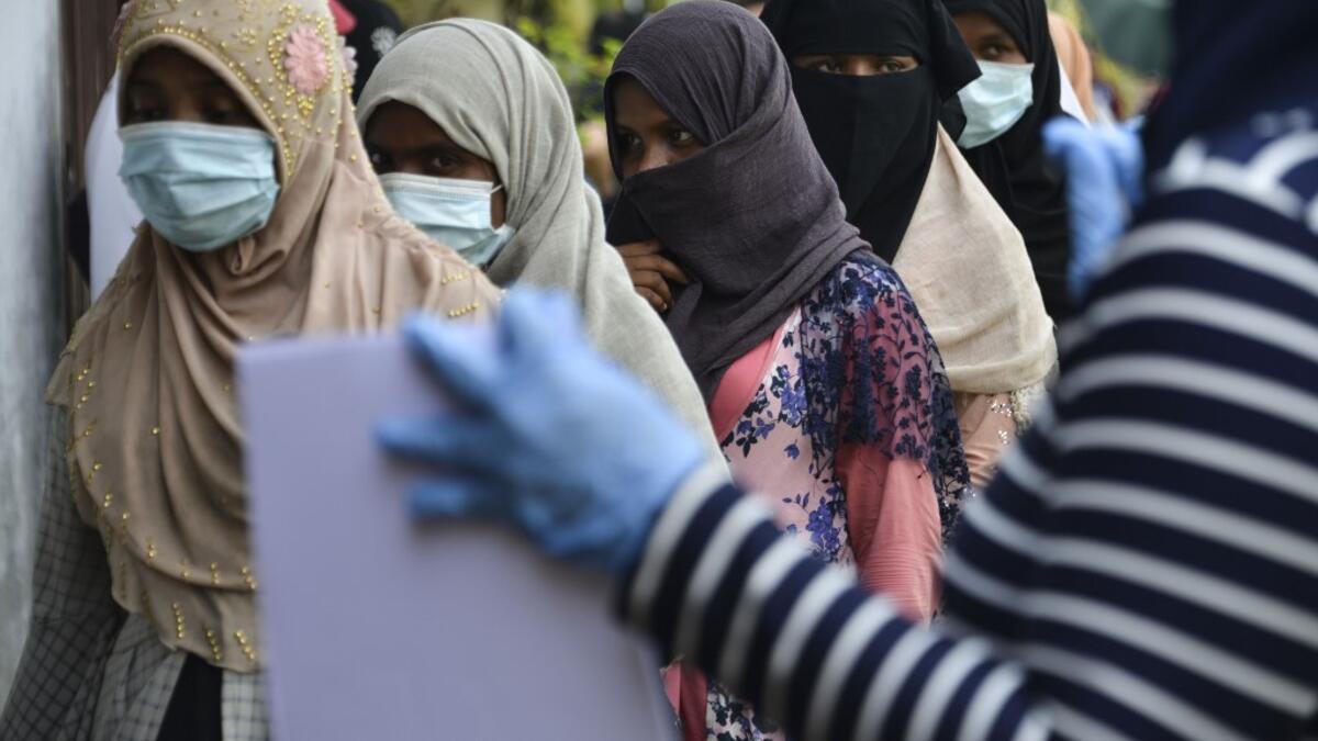 Rohingya woman from Myanmar queue up as they go through identification procedures by Indonesian police at the immigration detention centre in Lhokseumawe in Indonesia's North Aceh Regency on June 26, 2020. Nearly 100 Rohingya asylum seekers stranded off the coast of Indonesia were pulled to shore on June 25 by locals angered at the refusal of authorities to give them shelter over coronavirus fears. CHAIDEER MAHYUDDIN / AFP